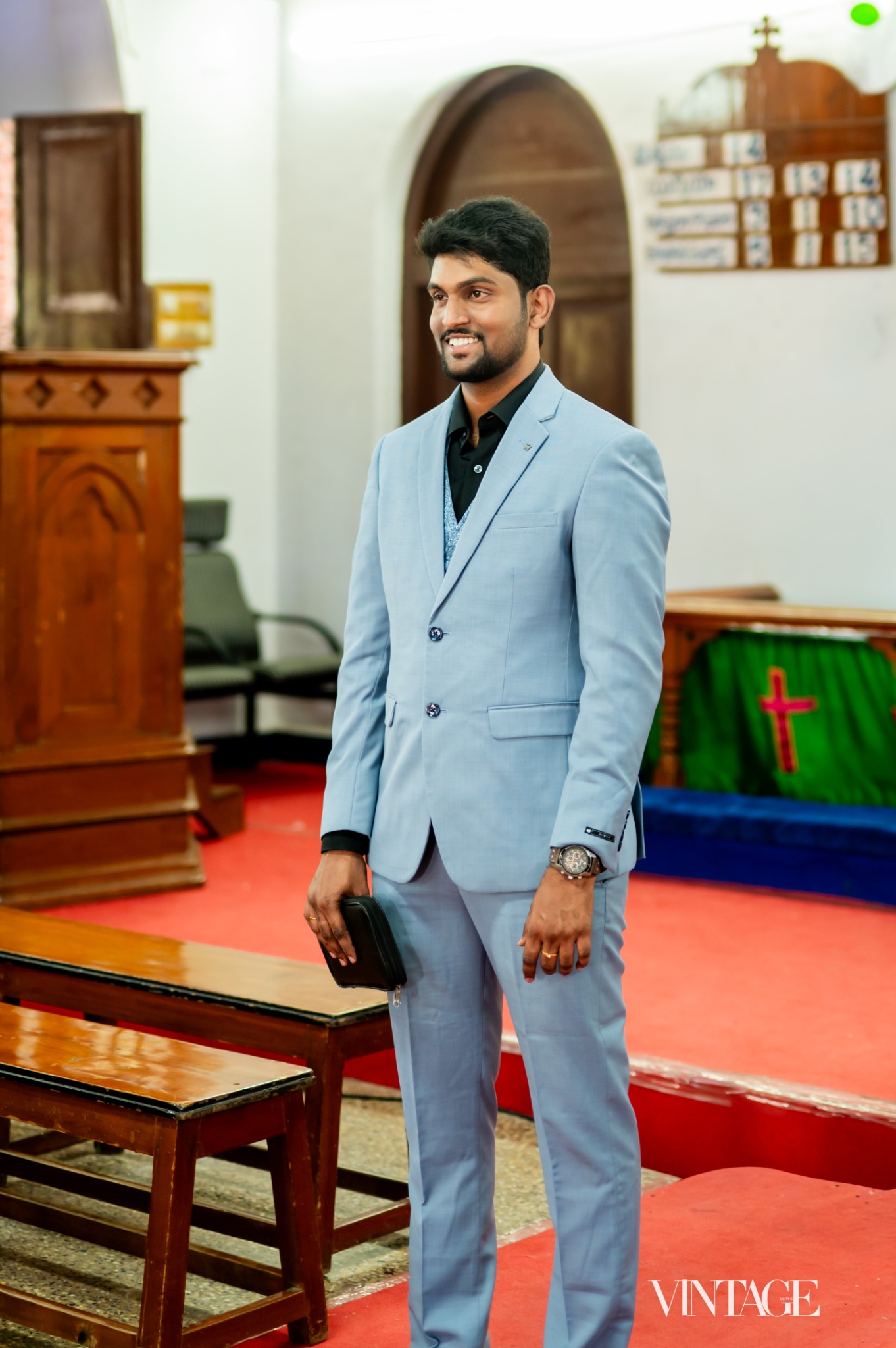 Ratan wearing a light blue suit inside a church