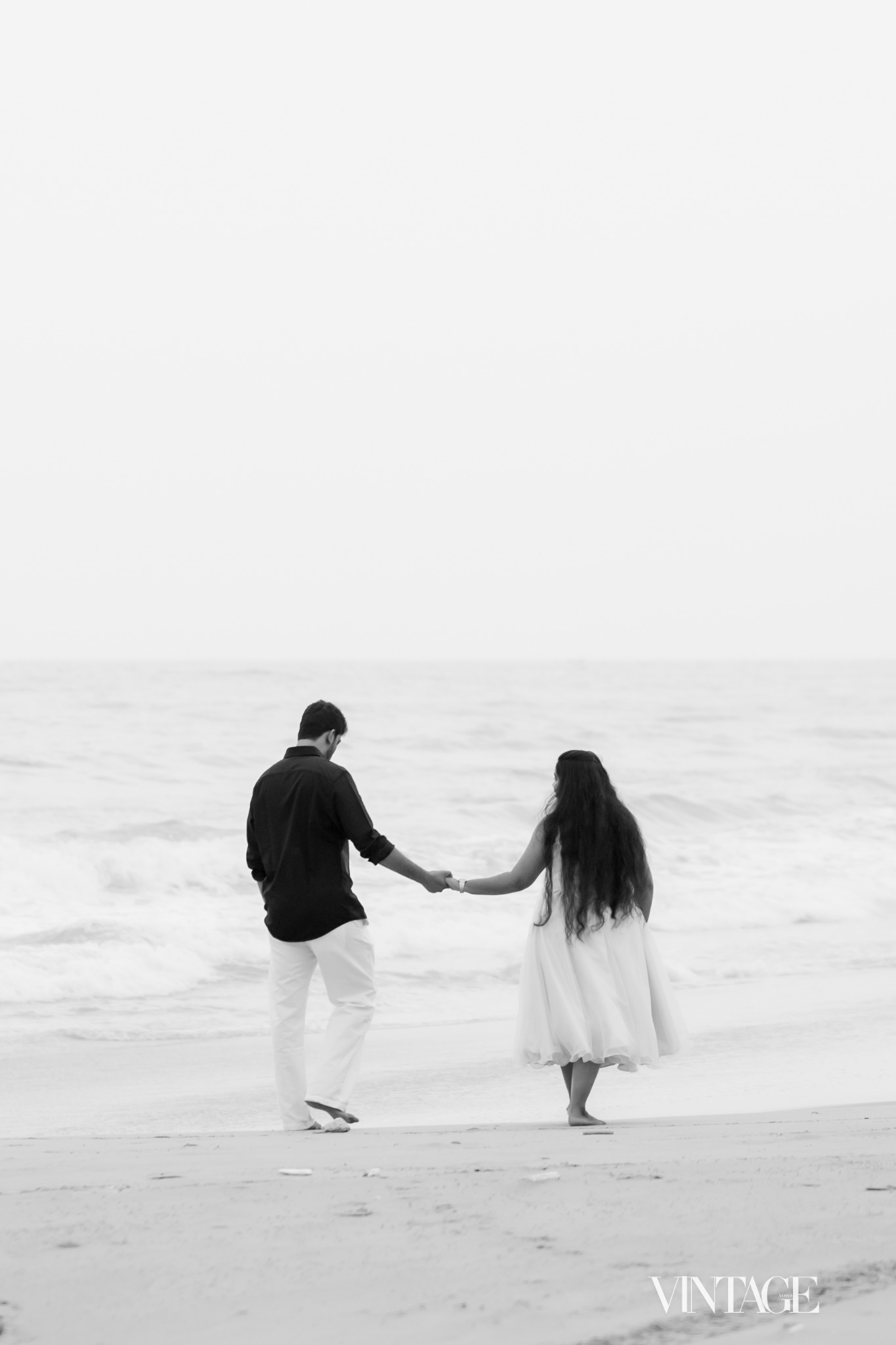 Ratan and Betsy holding hands at the ocean